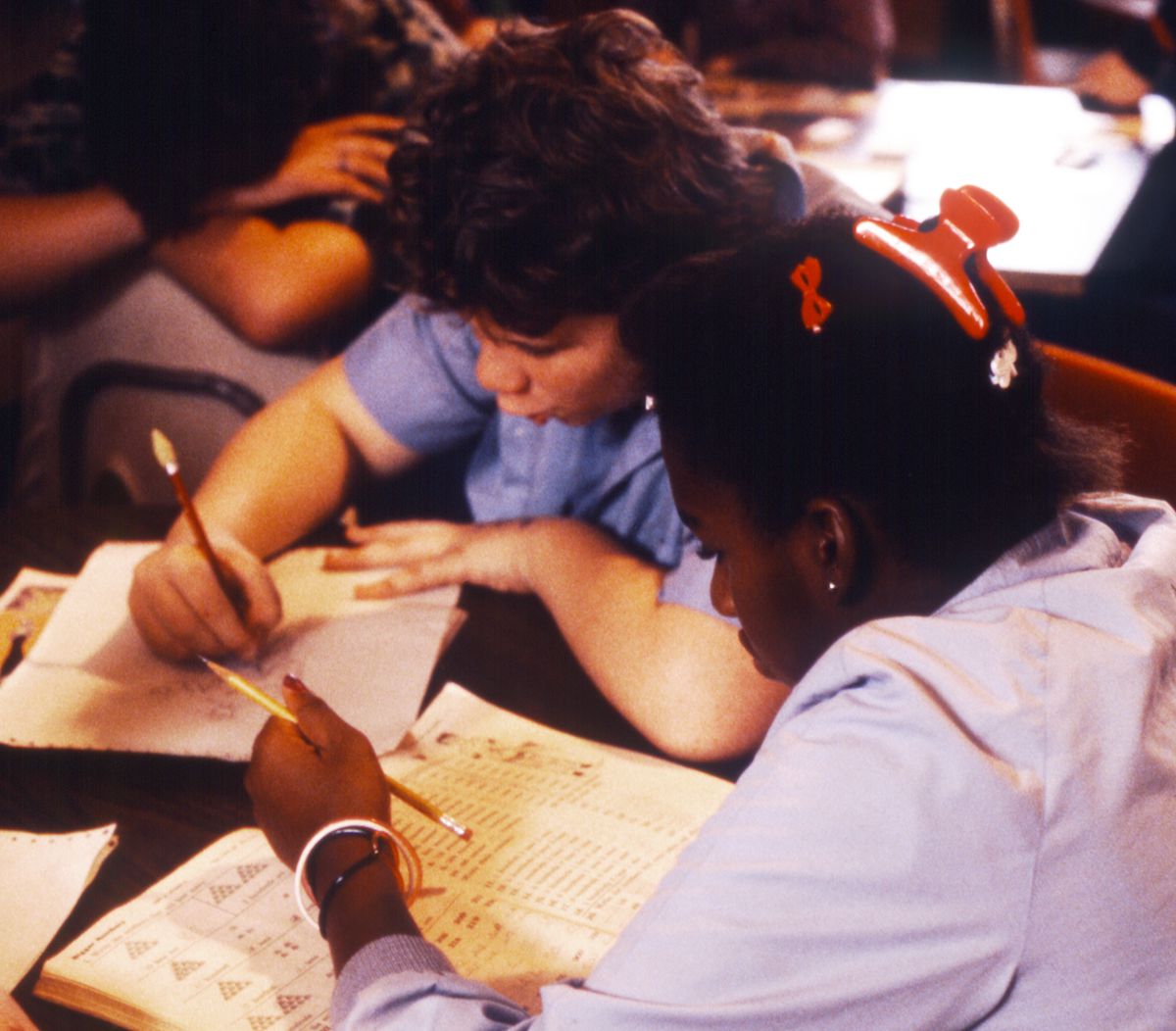 A girl working on math and a boy working on drawing