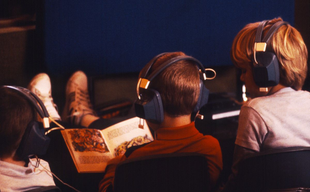 Three boys using a book-tape set